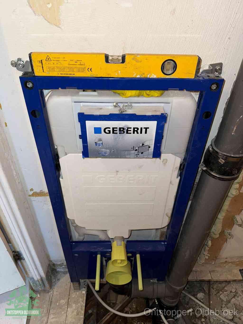 Een Geberit inbouwreservoir met frame voor een hangtoilet tegen de wand, met de afvoerbocht naar de vloer, kenmerkend voor een verstopt hangtoilet in Oldebroek