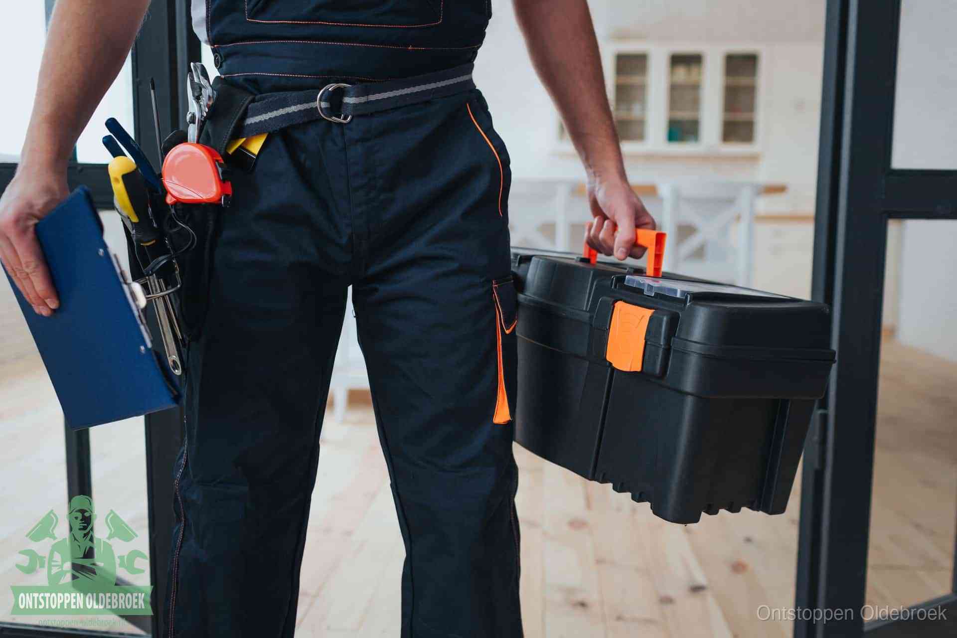 Een monteur met gereedschapsriem en klembord in een keuken, klaar om een transparante prijs voor het gootsteen ontstoppen in Oldebroek te geven