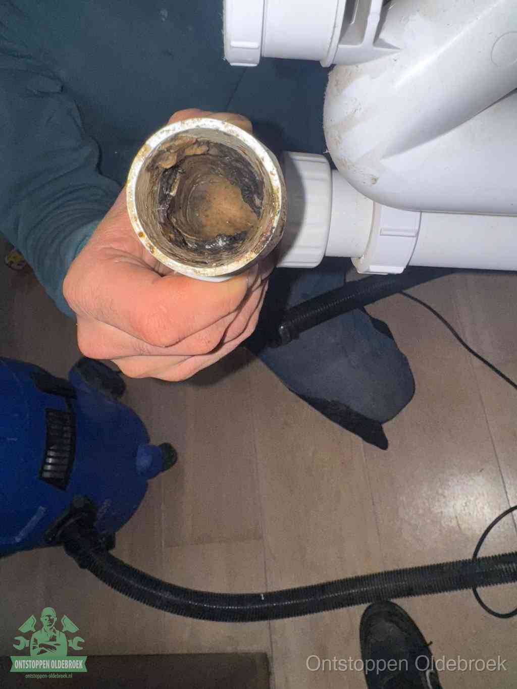 Een losgekoppelde afvoerbuis die van binnen volledig is dichtgeslibd met vet en aanslag, de meest voorkomende oorzaak van een verstopte gootsteen in Oldebroek