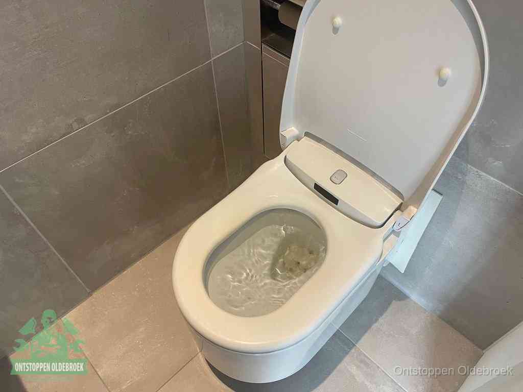 Een toiletpot vol troebel water met drijvend papier en restanten, de meest voorkomende oorzaak van een verstopte wc in Oldebroek